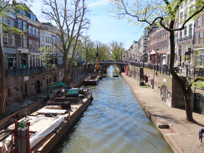 848759 Gezicht over een vanwege de coronacrisis vrijwel uitgestorven Oudegracht, vanaf de Gaardbrug te Utrecht richting ...